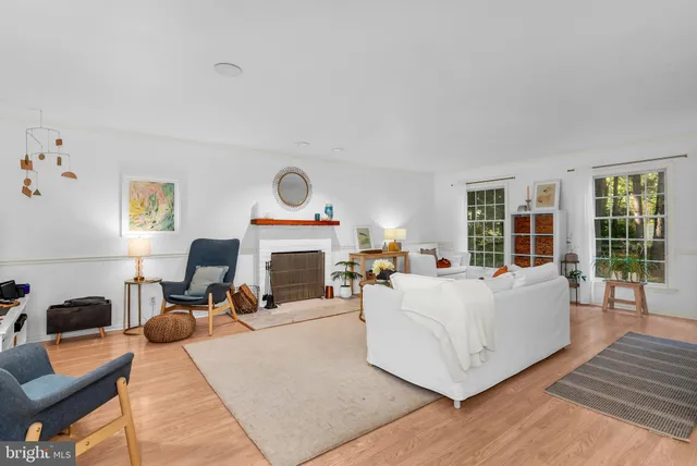 a living room with furniture a fireplace and a large window