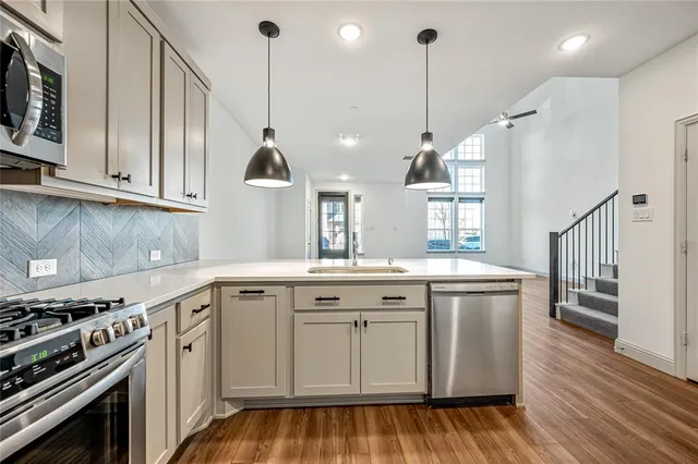 a kitchen that has a sink a stove and cabinets