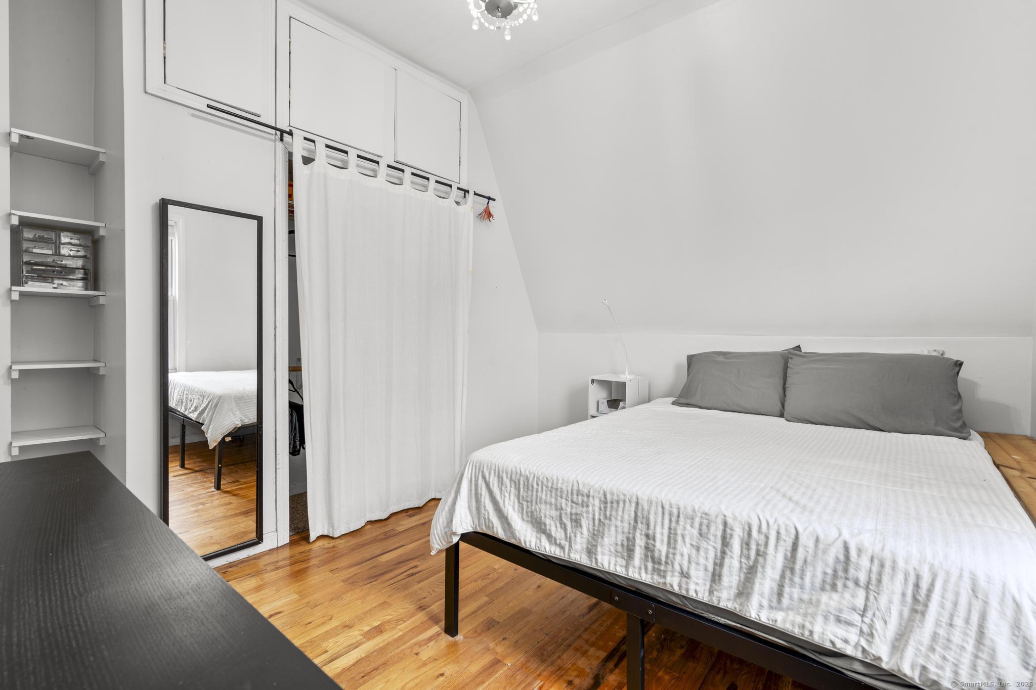 709 Tunxis Hill Road Fairfield, CT 06825 - Photo 20 of 30 a bedroom with a bed and wooden floor