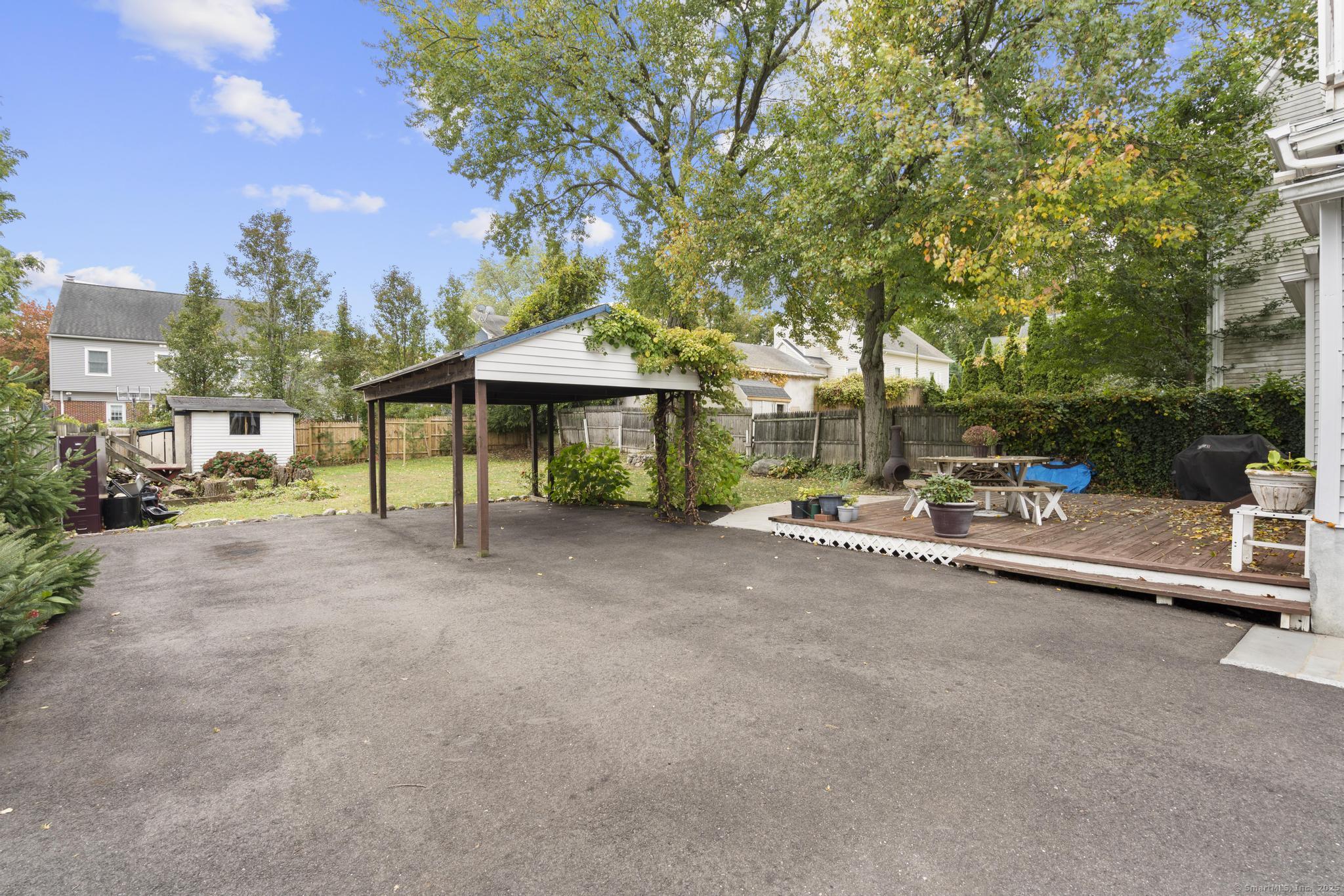 709 Tunxis Hill Road Fairfield, CT 06825 - Photo 25 of 30 a view of a patio with table and chairs under an umbrella