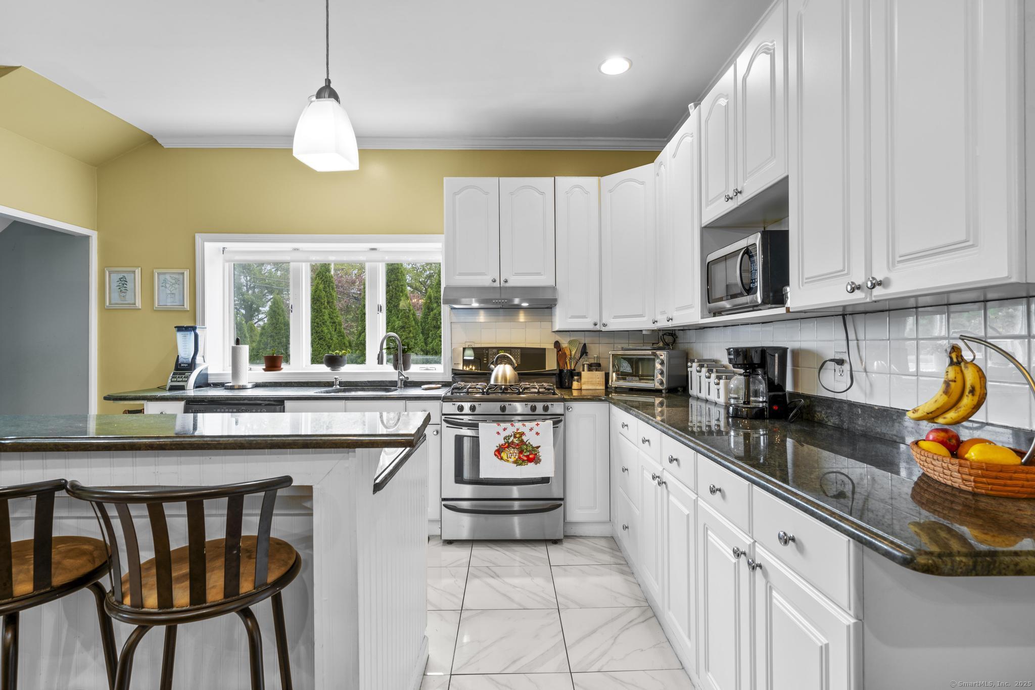 709 Tunxis Hill Road Fairfield, CT 06825 - Photo 9 of 30 a kitchen with stainless steel appliances granite countertop a stove top oven a sink dishwasher and white cabinets