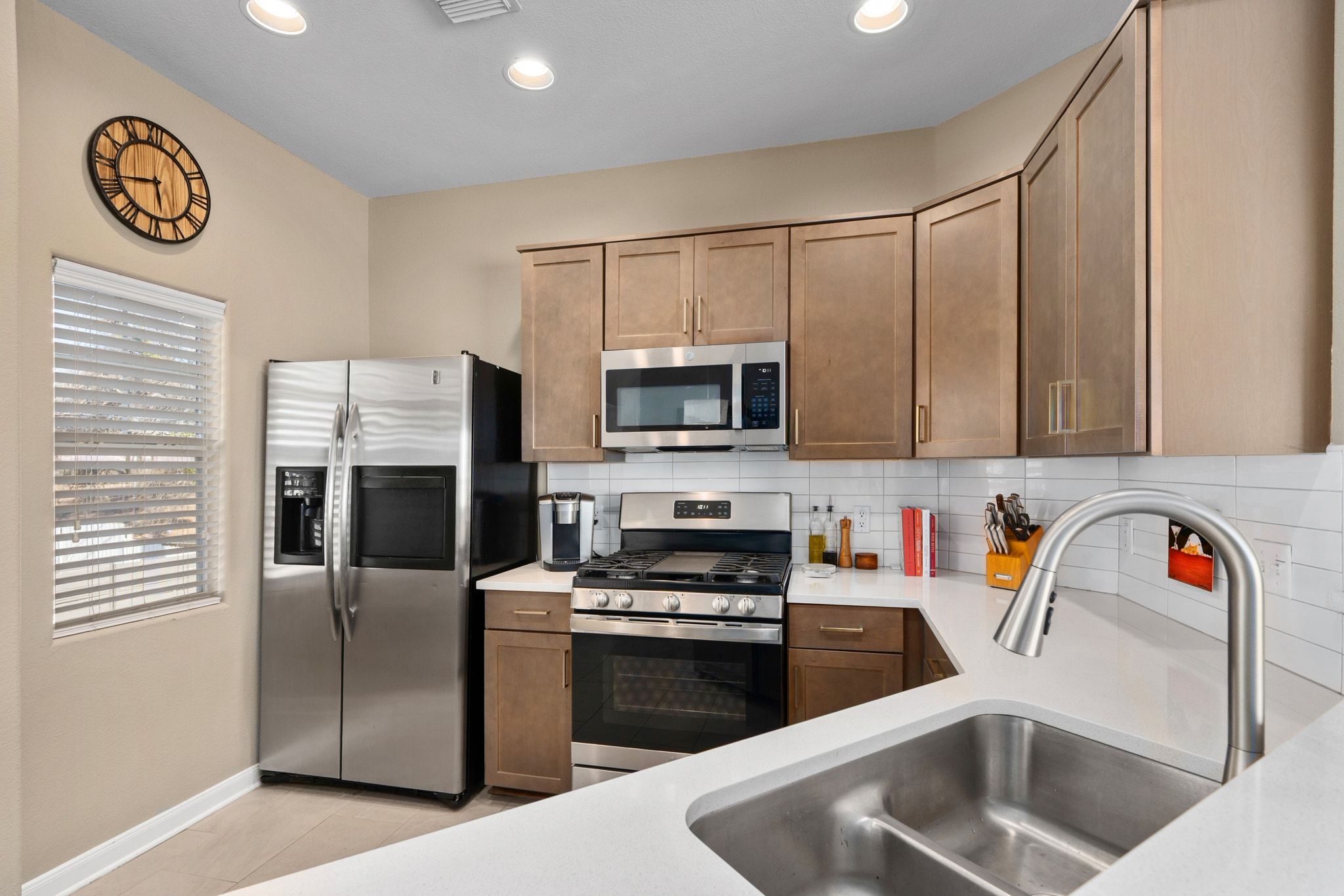 2905 Saville Loop Austin, TX 78741 - Photo 14 of 30 a kitchen with stainless steel appliances granite countertop a refrigerator a stove a sink and a microwave with wooden floor