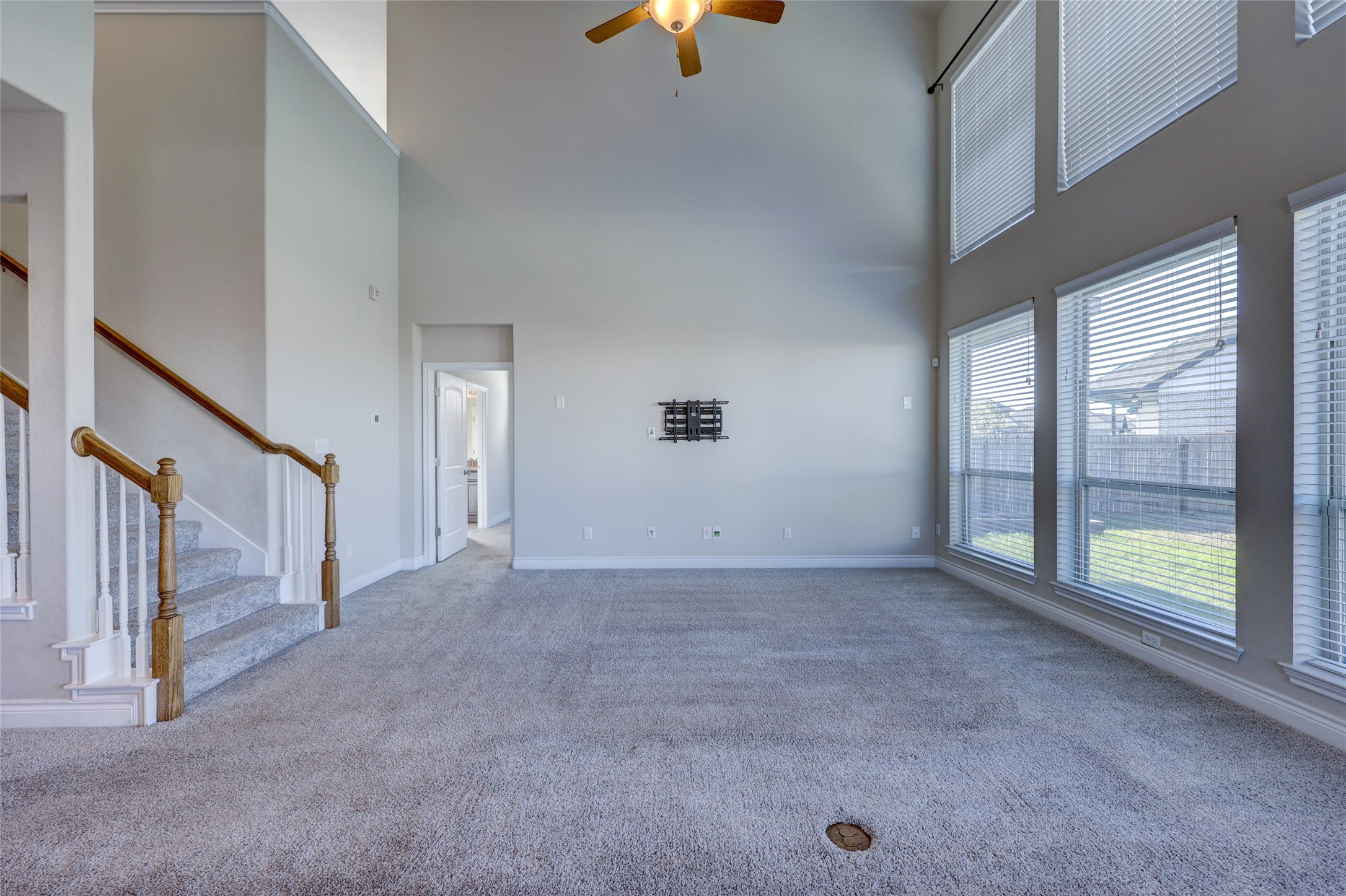 431 Millard Street Georgetown, TX 78628 - Photo 14 of 36 Unfurnished living room with a ceiling fan, carpet floors, and a high ceiling