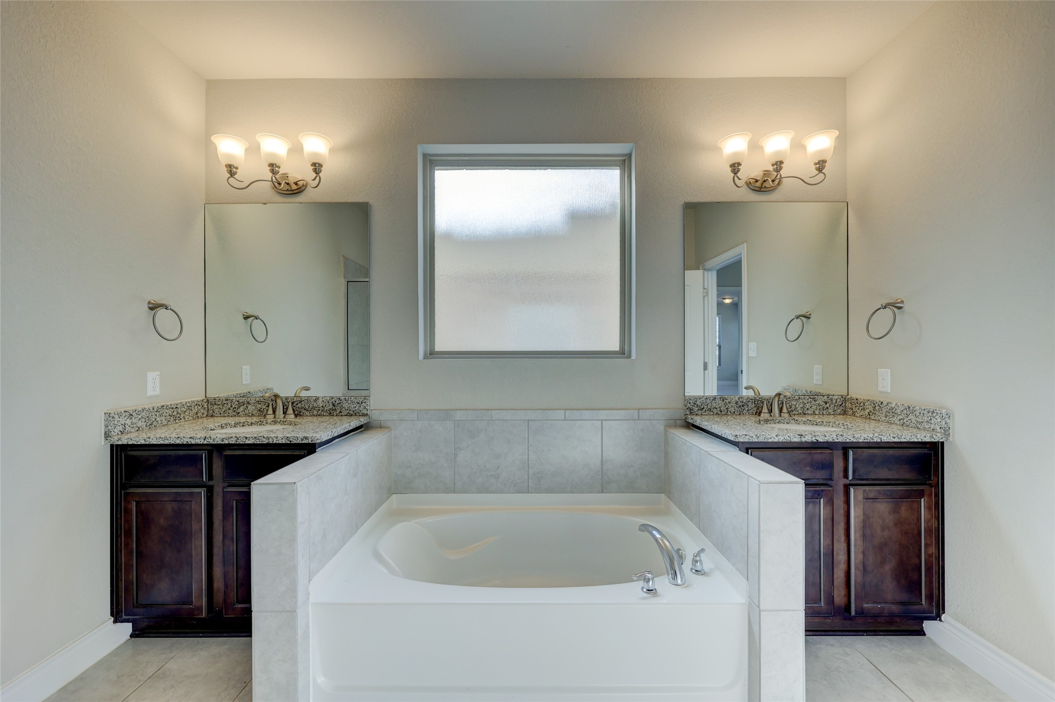 431 Millard Street Georgetown, TX 78628 - Photo 20 of 36 Bathroom with two vanities, a garden tub, and light tile patterned floors