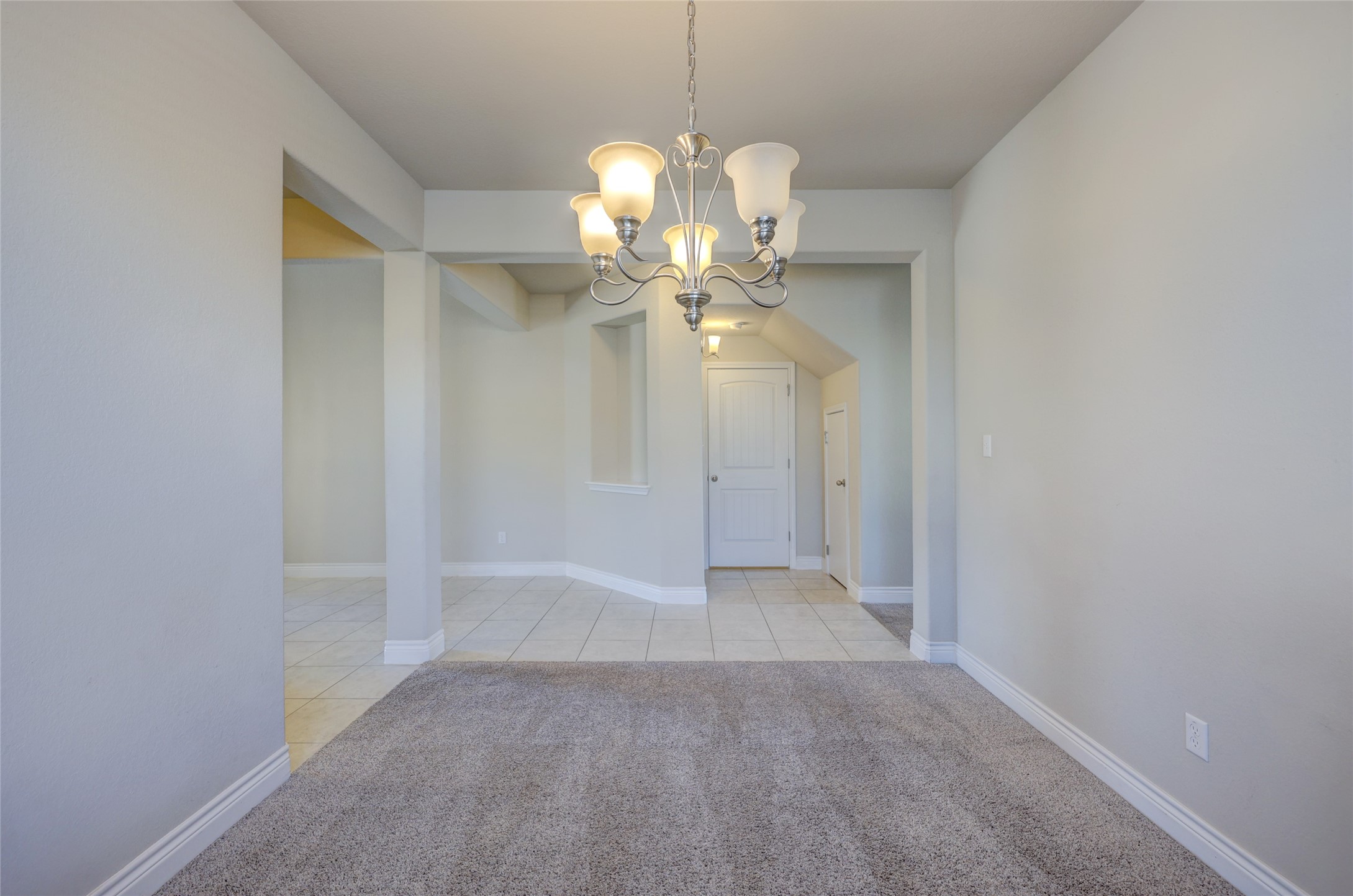 431 Millard Street Georgetown, TX 78628 - Photo 7 of 36 Unfurnished dining area with hanging lights, arched walkways, light carpet, and light tile patterned floors