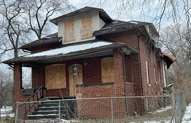 a view of a house with a door and a large tree