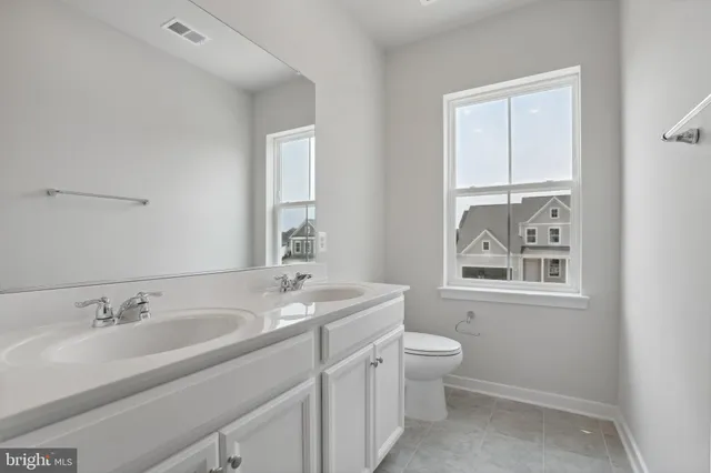 a bathroom with a granite countertop sink toilet and mirror