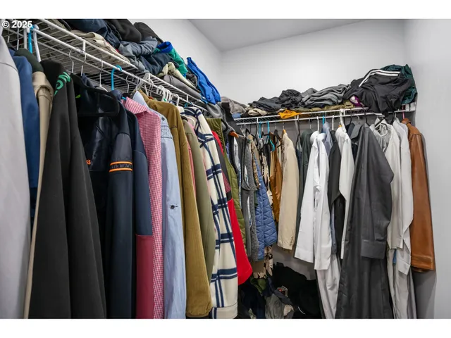a view of walk in closet with clothes and shoes