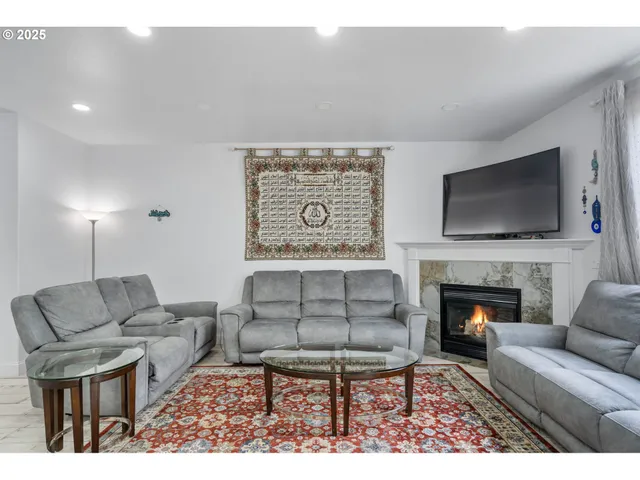 a living room with furniture a flat screen tv and a fireplace