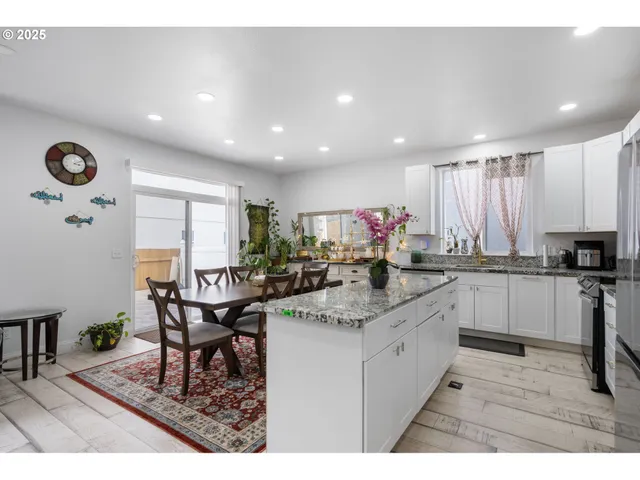 a kitchen with a dining table chairs and white cabinets