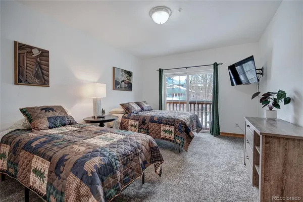 a bedroom with a bed and a potted plant on dresser