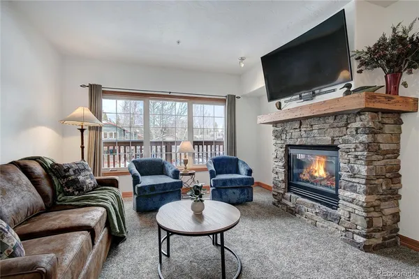 a living room with furniture a flat screen tv and a fireplace