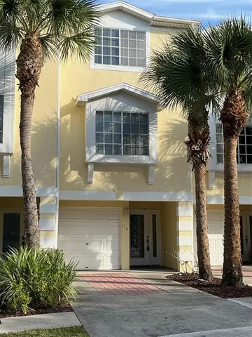 a front view of a house with a tree