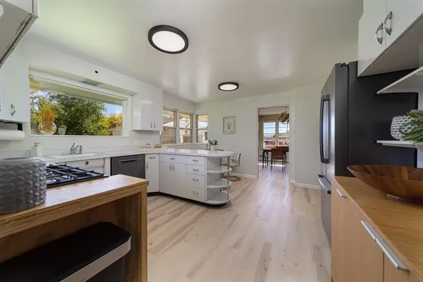 a kitchen with stainless steel appliances a stove sink and wooden floor