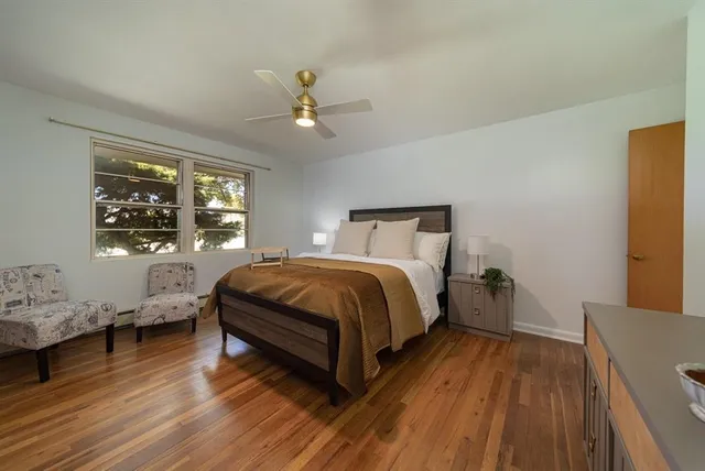 a spacious bedroom with a bed and wooden floor