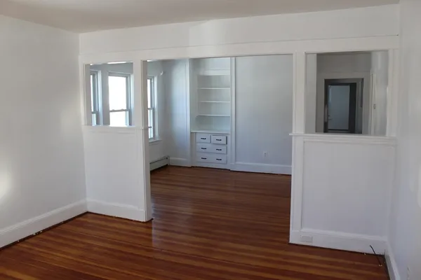 an empty room with wooden floor and closet