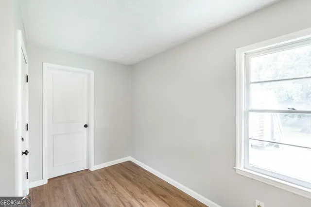 a view of a small space with wooden floor and a window