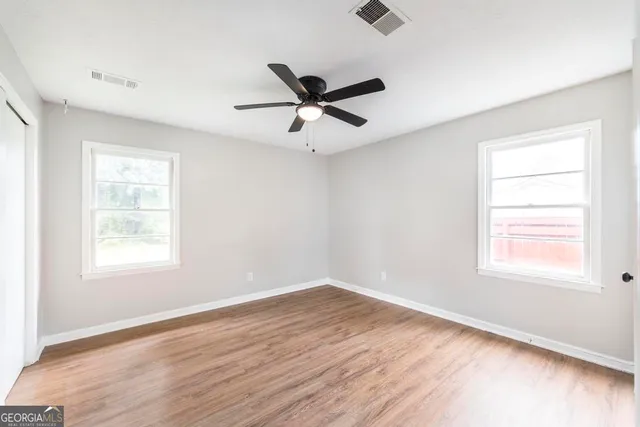 a view of a room with wooden floor and windows