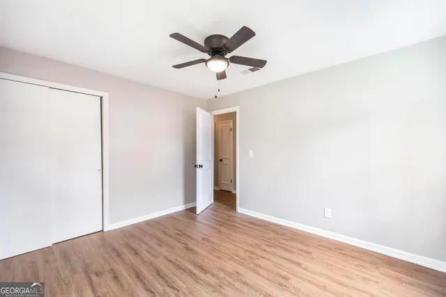 a view of room with wooden floor and ceiling fan