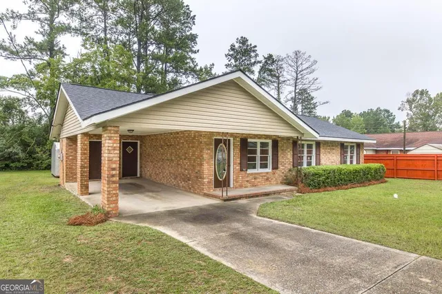 a front view of a house with yard and green space