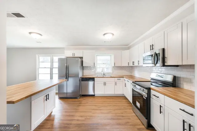 a large kitchen with stainless steel appliances granite countertop a stove a sink dishwasher and a refrigerator