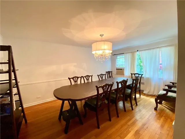 a view of a a dining room with furniture window and wooden floor