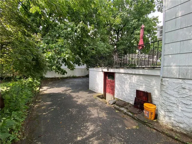 a backyard of a house with large trees and plants