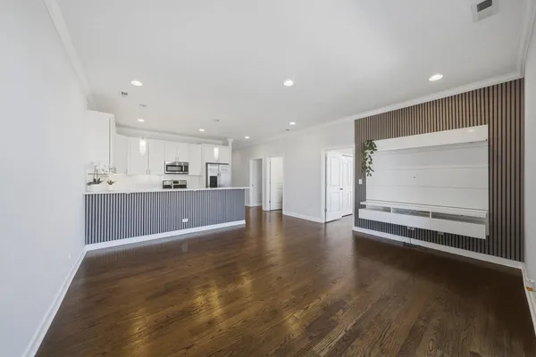 a view of kitchen with kitchen island wooden floor center island and stainless steel appliances
