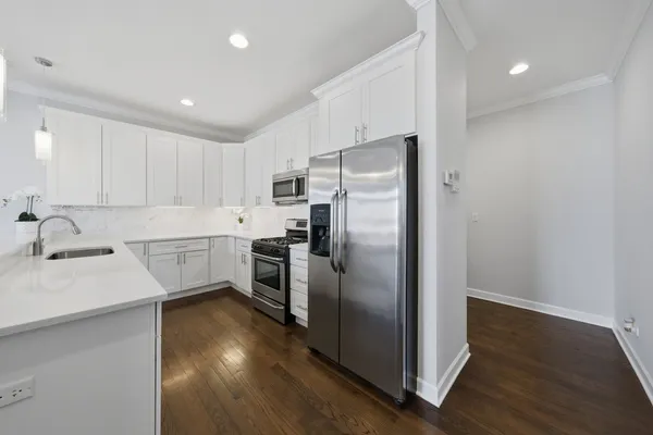 a kitchen with white cabinets and appliances