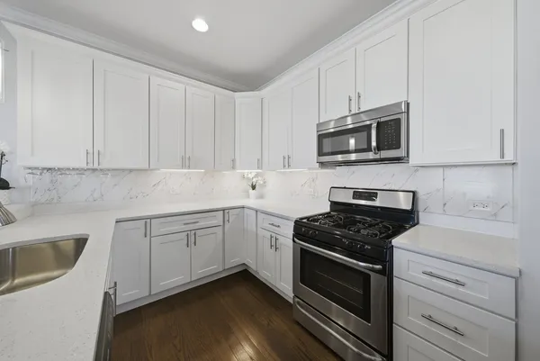 a kitchen with stainless steel appliances a sink dishwasher stove microwave and cabinets