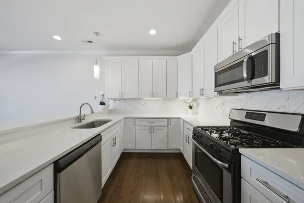 a kitchen with a white wooden floor cabinets and a sink