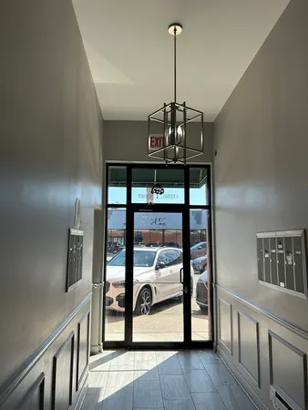 a view of a hallway with wooden floor staircase and a kitchen space
