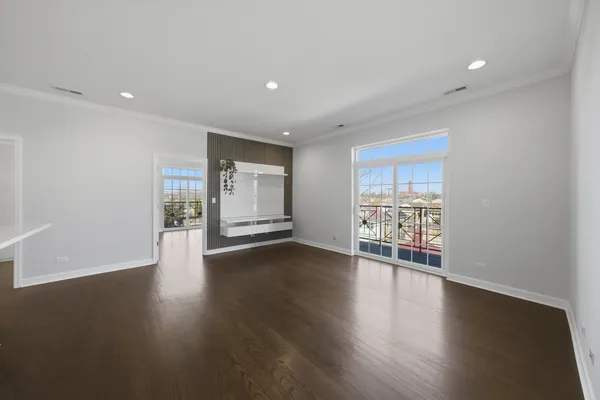 a view of empty room with wooden floor