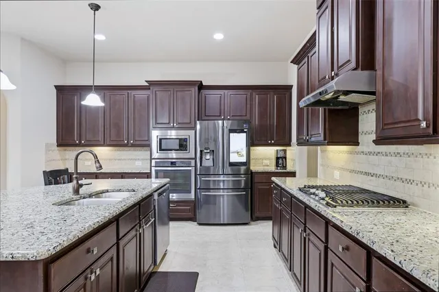 a kitchen with granite countertop wooden cabinets a center island a stove and a center island