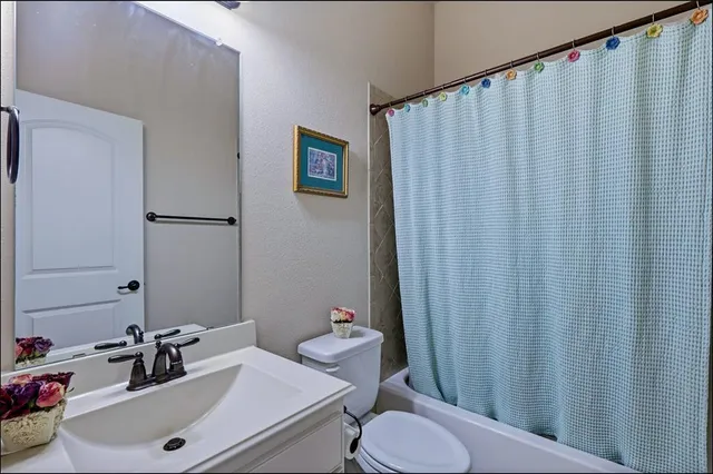 a bedroom with a bed a chandelier and dresser