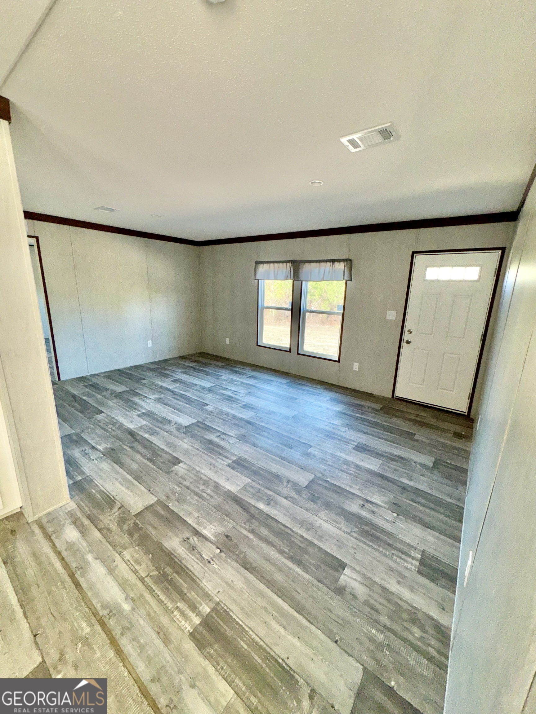 589 Ben Jackson Road Vidalia, GA 30474 - Photo 5 of 17 a view of an empty room with window and wooden floor