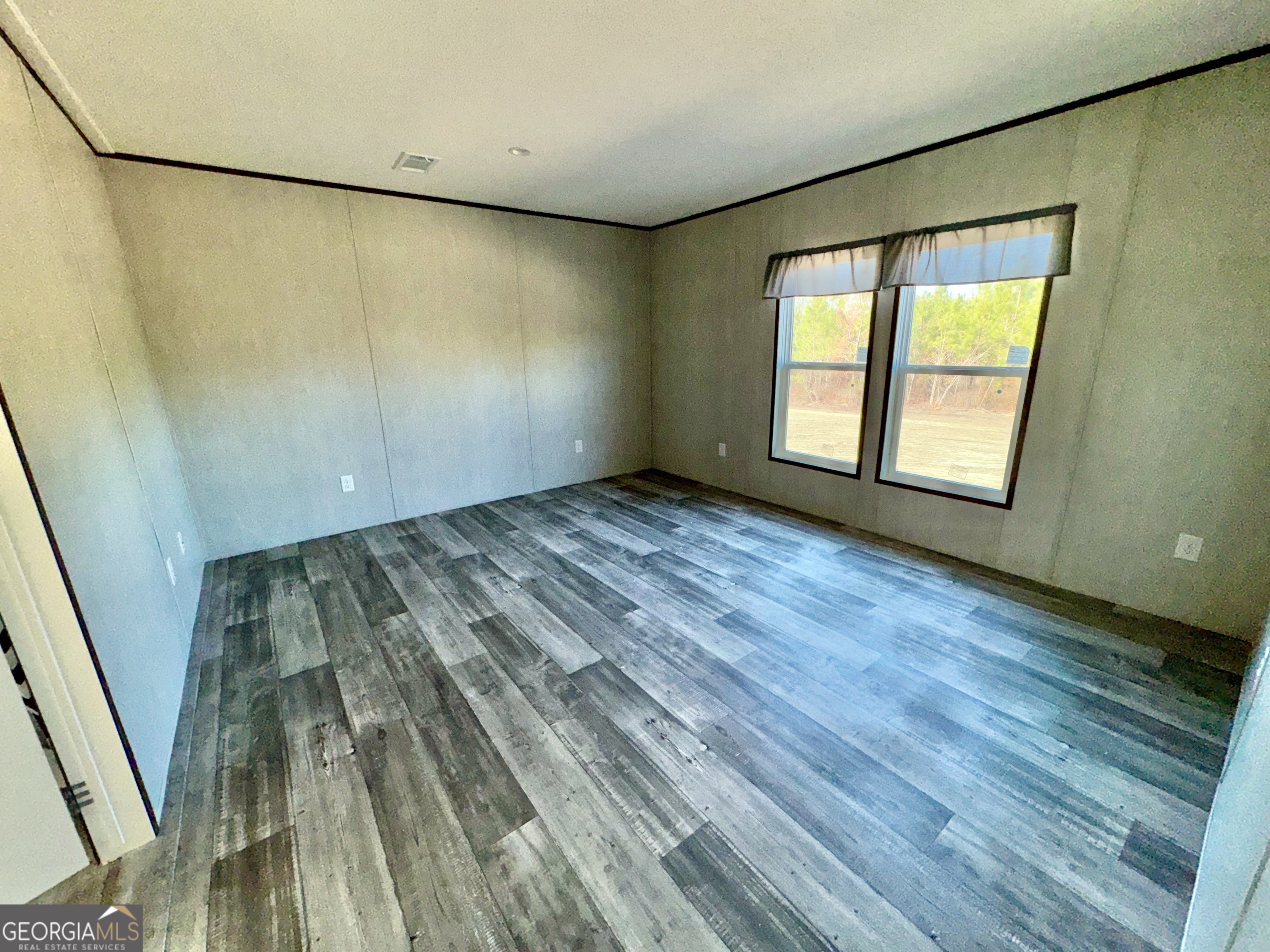 589 Ben Jackson Road Vidalia, GA 30474 - Photo 6 of 17 a view of an empty room with wooden floor and a window