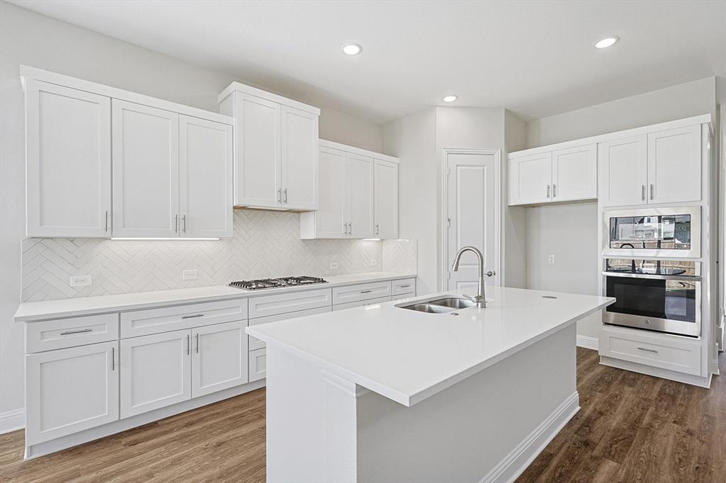11458 Chartwell Court Frisco, TX 75035 - Photo 11 of 32 a kitchen with a sink white cabinets and white appliances
