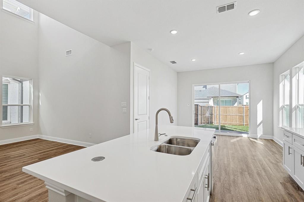 11458 Chartwell Court Frisco, TX 75035 - Photo 13 of 32 a kitchen with a refrigerator a stove and a sink with wooden floor