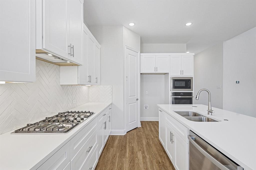 11458 Chartwell Court Frisco, TX 75035 - Photo 14 of 32 a kitchen with white cabinets sink and stainless steel appliances