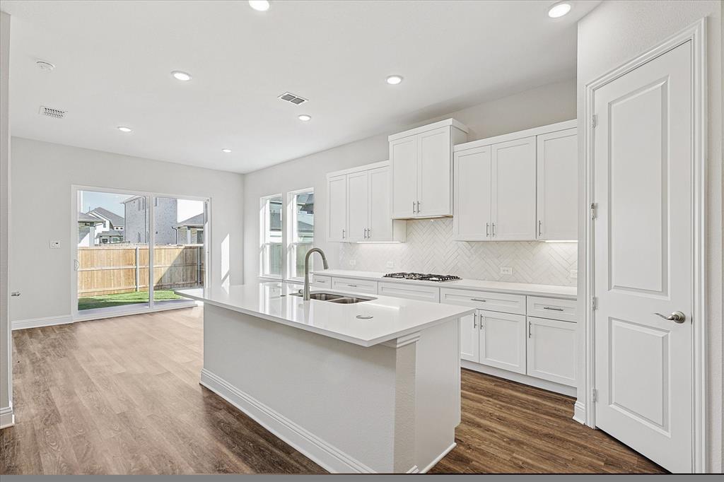 11458 Chartwell Court Frisco, TX 75035 - Photo 10 of 32 a kitchen with stainless steel appliances granite countertop a sink a stove and a refrigerator