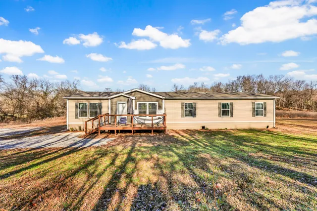 a view of a yard with plants and wooden fence