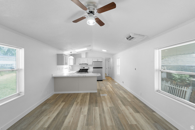 2600 North Hill Field Road, Unit 103A Layton, UT 84041 - Photo 6 of 31 Open-concept living space featuring wood-finish flooring, a contemporary kitchen with stainless steel appliances, white countertops, and light gray cabinetry