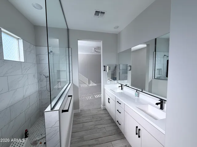 a spacious bathroom with double vanity and mirrors