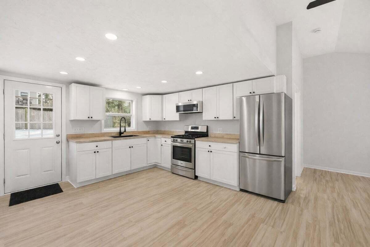 9 Blissful Lane East Wareham, MA 02538 - Photo 6 of 45 a kitchen with white cabinets stainless steel appliances and wooden floor