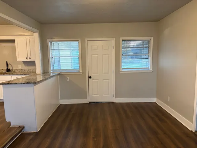 a view of a kitchen with wooden floor and a window