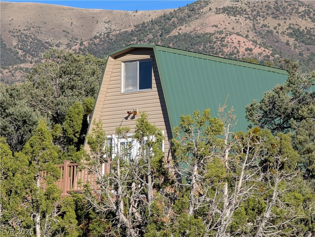 20502 Windsong Road Pioche, NV 89043 - Photo 13 of 30 Rugged mountains form a dramatic backdrop for this rustic retreat tucked among mature trees.