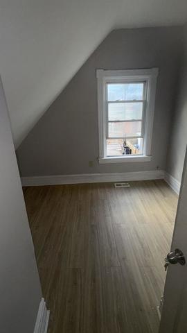 7726 South Maryland Avenue Chicago, IL 60619 - Photo 10 of 17 an empty room with wooden floor and windows