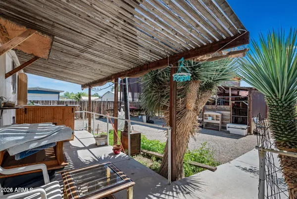 a patio with glass top table and chairs