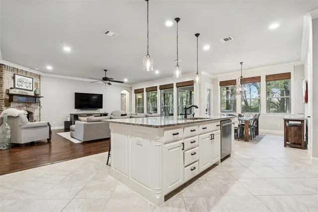 a kitchen with stainless steel appliances kitchen island granite countertop a stove and a view of living room